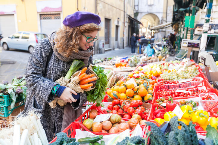 French woman choosing vegetables at a local market